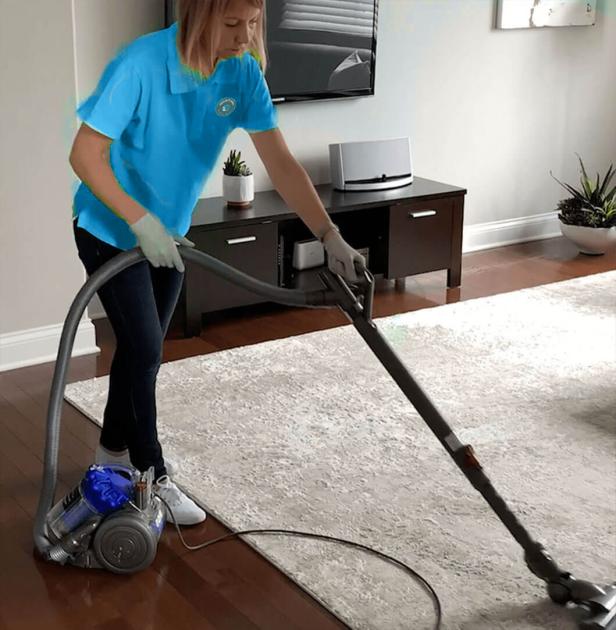 A Texas maid providing cleaning services in a living room with a vacuum.